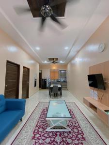 NSJay Guest House في Kampong Gong Balai: غرفة معيشة مع أريكة زرقاء وطاولة