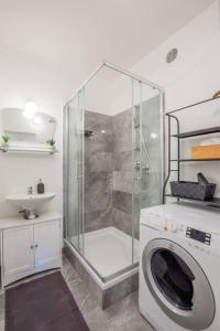 y baño con ducha y lavadora. en Cozy vintage apartment en Viena