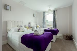 プールにあるPoppiesのベッドルーム1室(紫のシーツが敷かれたベッド2台、窓付)
