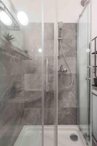 y baño con ducha y puerta de cristal. en Cozy vintage apartment en Viena