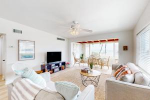 a living room with two couches and a tv at Ocean Beach Bungalow in Ormond Beach