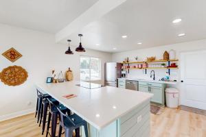 a kitchen with a white counter and blue stools at Ocean Beach Bungalow in Ormond Beach