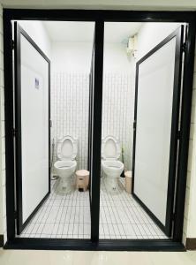 łazienka z 2 toaletami i 2 oknami w obiekcie HUG Backpackers w mieście Chiang Mai