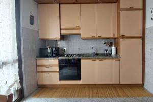 a kitchen with wooden cabinets and a stove top oven at Deliziosa Casa Mignon in Luisago