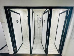 łazienka z czterema drzwiami i prysznicem w obiekcie HUG Backpackers w mieście Chiang Mai