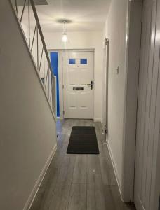 un pasillo con una puerta blanca y una alfombra en Entire house - Peaceful 3 bedroom home, en Rishton