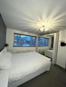 una camera con un letto bianco e due finestre di Entire house - Peaceful 3 bedroom home a Rishton