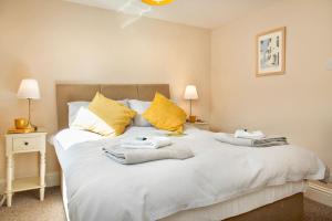 a bedroom with a large white bed with towels on it at Cosy Cottage rural village near Tavistock/sleeps 4 in Bere Alston