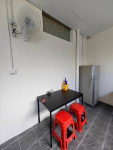 a room with a table and two red stools at WW Hostel 22A Private Shower in George Town