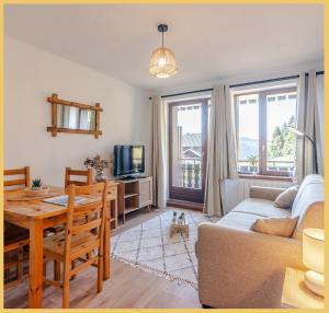 a living room with a couch and a table at Appartement I Sublime I Les Gets in Les Gets