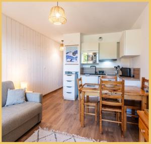a kitchen and living room with a table and a couch at Appartement T2 Sublime situé à LES GETS in Les Gets