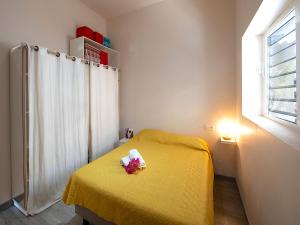 um quarto com uma cama amarela e uma janela em Villa Pinel em Cul de Sac