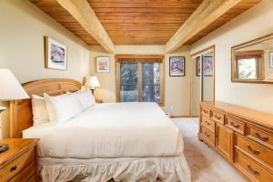 um quarto com uma cama branca e um tecto de madeira em Chateau Eau Claire Unit 17, Serene Condo Overlooking the River with Many Upgrades em Aspen