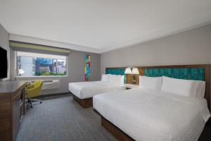 a hotel room with two beds and a television at Hampton Inn & Suites by Hilton Toronto Downtown in Toronto