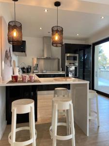 a kitchen with a large island with stools in it at L'Etoile de la Forêt in Bolquere Pyrenees 2000