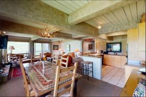 uma cozinha e sala de estar com mesa e cadeiras em Enclave 201, Snowmass Ski-In/Ski-Out Condo w/Shared Pool/Hot Tub/Gym/WiFi em Snowmass Village