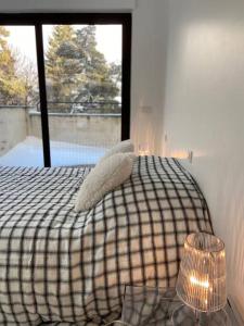 1 dormitorio con cama con almohadas y ventana en L'Etoile de la Forêt en Bolquere Pyrenees 2000