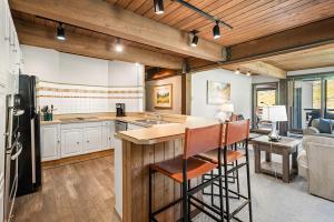 a kitchen with a bar and a living room at Enclave 208, Snowmass Ski-In/Ski-Out Condo w/Shared Pool/Hot Tub/WiFi in Snowmass Village