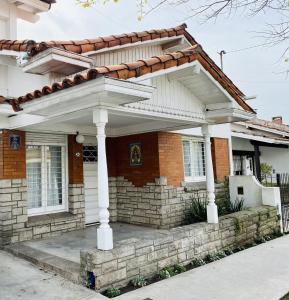 una casa con un grande pergolato bianco di Chalet Quintana a Mar del Plata