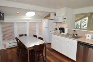 a kitchen with a table and a kitchen with white appliances at Old Hundred Unit 102, Townhouse with Treetop Views & Excellent Location, 3 Blocks to Ski Slopes in Aspen