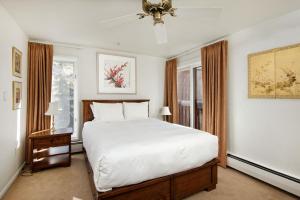 a bedroom with a large bed and a window at Old Hundred Unit 102, Townhouse with Treetop Views & Excellent Location, 3 Blocks to Ski Slopes in Aspen