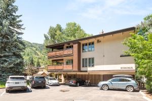 a building with cars parked in a parking lot at Little Nell Condominiums Unit 11, Top Floor Condo with Mountain Views, 3 Blocks to Gondola in Aspen