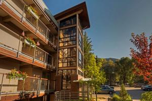 an apartment building with balconies and a parking lot at Chateau Eau Claire Unit 1, Stylish Condo Overlooking the River, Walking Distance to Downtown in Aspen