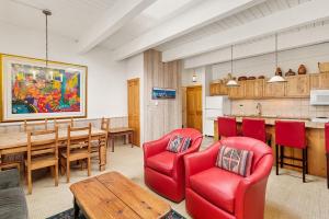 un soggiorno con tavolo e sedie rosse di Chateau Chaumont Unit 19, Spacious Top-Floor Condo with Great Location ad Aspen