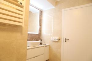 La salle de bains est pourvue d'un lavabo blanc et d'un miroir. dans l'établissement Monte de Palma- Quinta Biodinâmica Momentos Únicos, à Évora