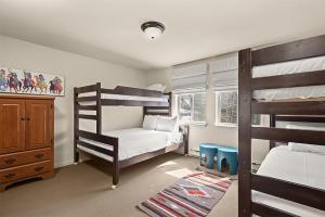 a bedroom with two bunk beds and a window at Silverglo Condominiums Unit 308, Expansive 4 BD Condo, Walking Distance to Town with Pool Access in Aspen