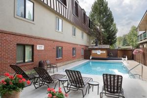 a swimming pool with chairs and a building at Silverglo Condominiums Unit 308, Expansive 4 BD Condo, Walking Distance to Town with Pool Access in Aspen