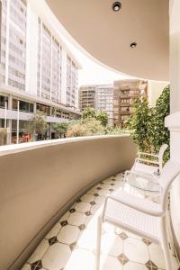 2 bancos blancos en un balcón con edificios en TARATA BOUTIQUE HOTEL, en Lima