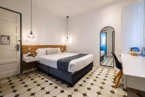 um quarto de hotel com uma cama e um espelho em TARATA BOUTIQUE HOTEL em Lima