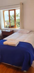 a bedroom with a bed with a blue blanket on it at Casona Mollepata in Mollepata