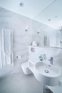 La salle de bains blanche est pourvue d'un lavabo et de toilettes. dans l'établissement FINESTATE Coliving Champs-Elysées, à Paris