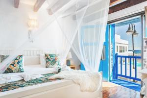 a living room with a white couch and a window at Eco Fisherman's Seafront Cottage in Arrieta