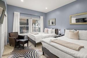 een slaapkamer met 2 bedden, een stoel en een raam bij Durant Unit D5, Luxury Condo with Beautiful Furnishings, Great Views, and Central A/C in Aspen