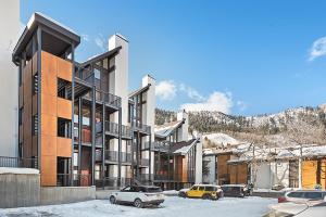 a building with cars parked in the snow at Fifth Avenue Unit 202, 2 Bedroom + Loft Condo, Huge Windows & Views. 2 Blocks to Skiing! in Aspen +5 photos