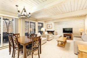 a living room with a table and chairs and a couch at Chateau Roaring Fork Unit 37, Spacious Condo, Close to Downtown. Pool, Hot Tub, Fitness Center in Aspen