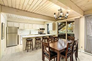 a kitchen with a table and chairs and a kitchen with a refrigerator at Chateau Roaring Fork Unit 37, Spacious Condo, Close to Downtown. Pool, Hot Tub, Fitness Center in Aspen