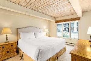 a bedroom with a large white bed and a window at Chateau Roaring Fork Unit 37, Spacious Condo, Close to Downtown. Pool, Hot Tub, Fitness Center in Aspen