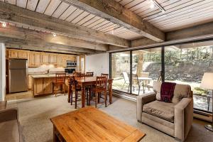 a kitchen and living room with a table and chairs at Chateau Eau Claire Unit 8, Riverfront Condo, Walking Distance to Town in Aspen