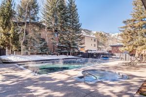 a swimming pool in a yard with snow on the ground at Chateau Eau Claire Unit 8, Riverfront Condo, Walking Distance to Town in Aspen