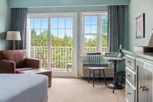 a bedroom with a bed and a chair and a desk at The Harbor Front Inn in Greenport