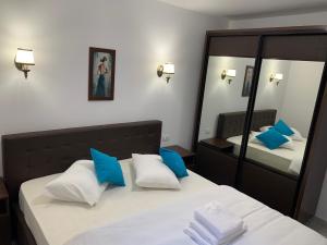 a bedroom with two beds with blue and white pillows at Vila F&C in Braşov