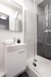 a white bathroom with a shower and a sink at Pensjonat Everest in Szklarska Poręba
