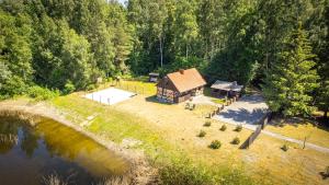 an aerial view of a cabin next to a lake at Amber House su sūkurine vonia in Agluonėnai