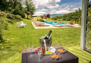 una mesa con una botella de vino y copas de vino en Borgo Canapegna - 2 private villas and 3 private pools in the heart of Le Marche, en Fabriano