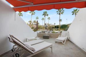 un patio con una hamaca, una silla y una sombrilla en Parque Santiago 2 Luxury Apartment en Playa de las Americas