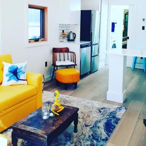 ein Wohnzimmer mit einem gelben Sofa und einem Tisch in der Unterkunft Tiny House Haven in Peterborough